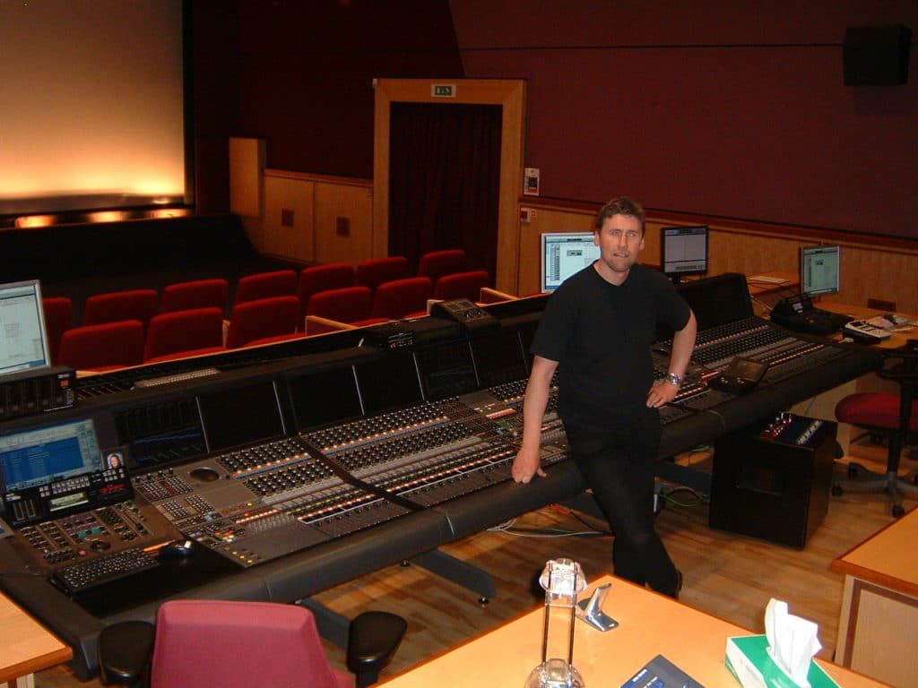 Iain Tyrrell standing next to the mixing desk in Pinewood Studio One.