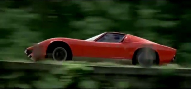 The orange Lamborghini Miura from the film The Italian Job driving through the Alps.
